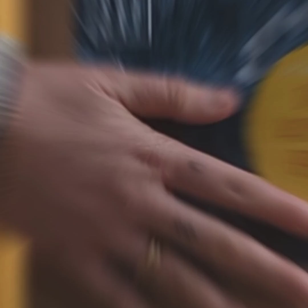 Hand holding All About Kombucha deluxe brewing kit box in front of a yellow door with text overlay reading 'Kombucha DIY Kit'